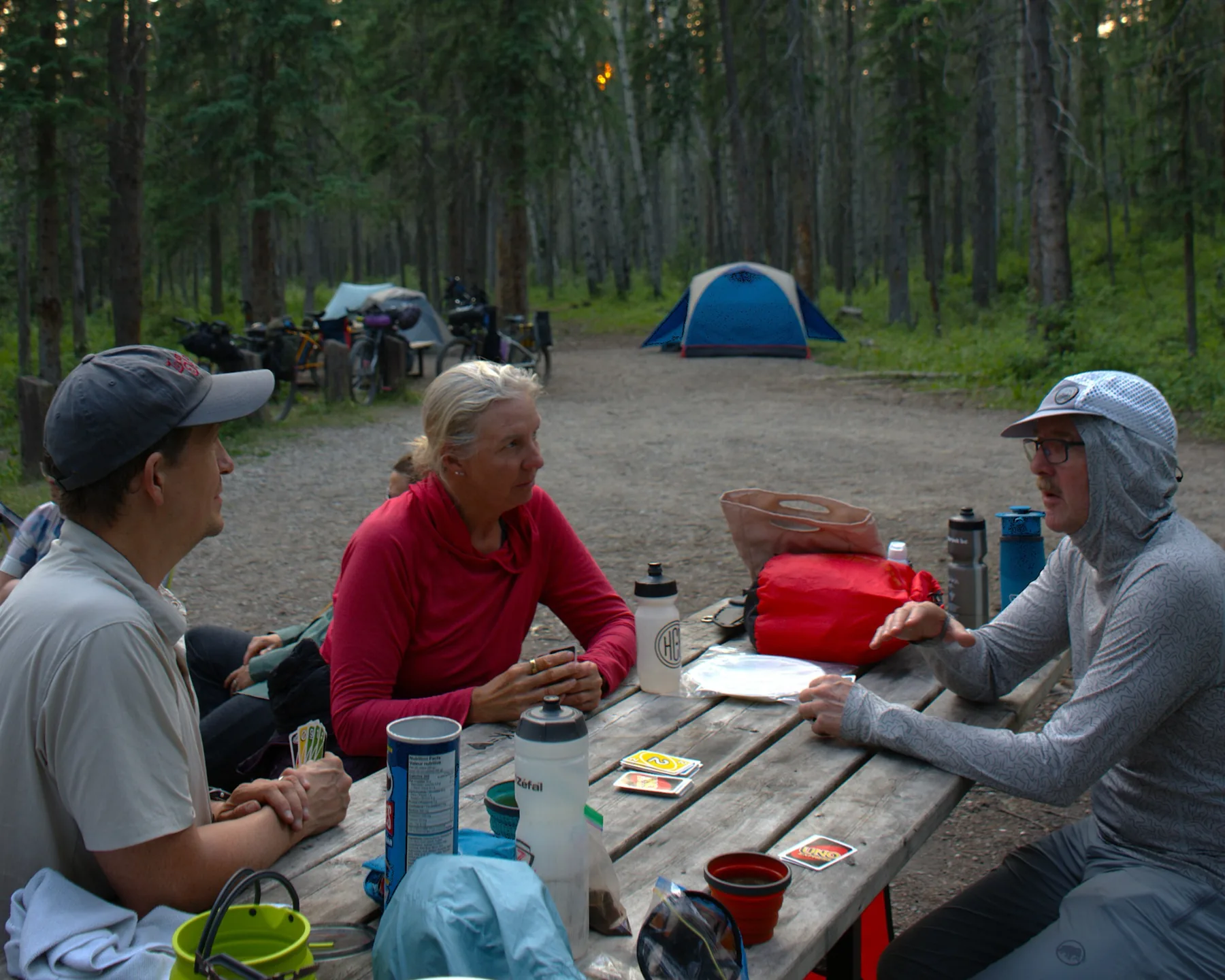 Bikepackers sharing a meal and cards at camp