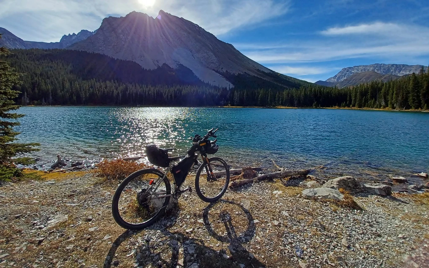 Loaded bike beside blue mountain water on the western portion of GRAAB