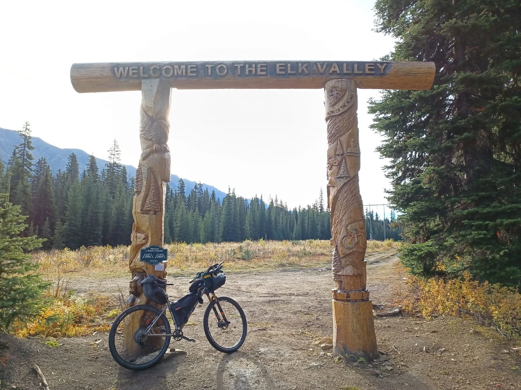 Loaded bike beneath the Welcome to the Elk Valley carved arch at the GRAAB start